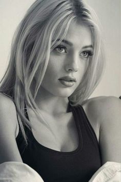 black and white photograph of a woman with blonde hair wearing a tank top looking at the camera