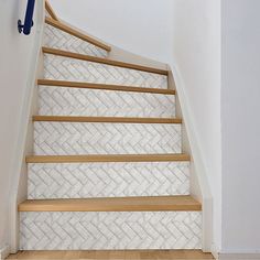 a set of stairs with wooden handrails next to a white wall