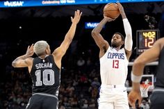 two basketball players are trying to block the ball