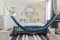 a bedroom with a bed, chair and hammock