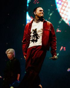 a man standing on top of a stage wearing a red jacket