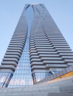 a very tall building with many windows on it's side and the sky in the background