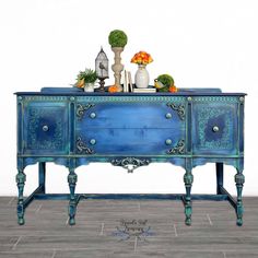 a blue painted dresser with flowers on top