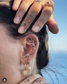 a close up of a person with tattoos on their ears and behind her ear is a ring