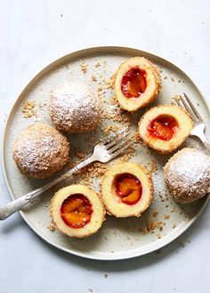 desserts on a plate with powdered sugar and jelly in the middle, ready to be eaten