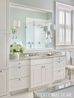 an image of a bathroom with white cabinets and marble counter tops on the facebook page