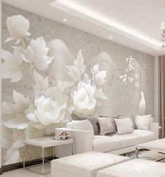 the living room is decorated in white and has flowers on the wall, along with couches