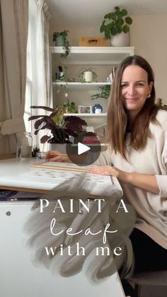 a woman sitting at a desk in front of a computer with the words paint a leaf with me on it