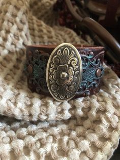 "🔸🔸orders are delayed by a few days this week. Thank you for your patience Country leather bracelet cuff, western jewelry Embossed distressed genuine brown leather 1 1/2\" strap has been adorned with an oval southwestern silver concho which sets on a detailed antiqued copper filigree which has been given a rich patina. It is attached to the leather with two antiqued copper rivets. One antiqued copper snap has been placed to fit up to a 7 1/4\" wrist. I can add another snap if you would like a Brown Concho Jewelry For Rodeo, Brown Hand Tooled Jewelry For Rodeo, Hand Tooled Brown Jewelry For Rodeo, Brown Bohemian Leather Bracelet With Concho, Western Brown Hand-tooled Jewelry, Western Leather Jewelry With Concho, Vintage Brown Jewelry For Rodeo, Vintage Leather Bracelet With Concho, Western Style Hand Tooled Leather Bracelets