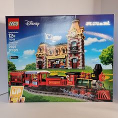 a lego box with a train on the tracks in front of a castle like building