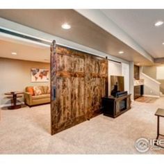 a living room filled with furniture and a flat screen tv on top of a wooden sliding door