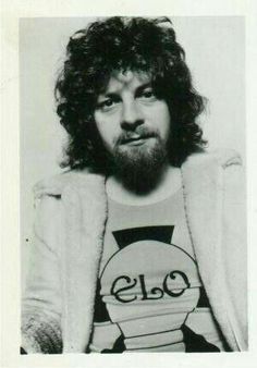 an old black and white photo of a man with long hair wearing a t - shirt