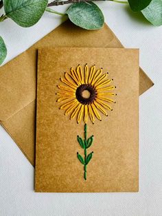 a brown card with a yellow flower on it