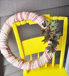 a yellow chair with a wreath on it