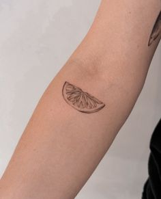 a tattoo on the arm of a person with a piece of fruit in it's middle