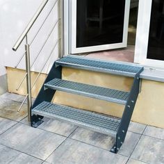 a set of stairs sitting on the side of a building next to a potted plant