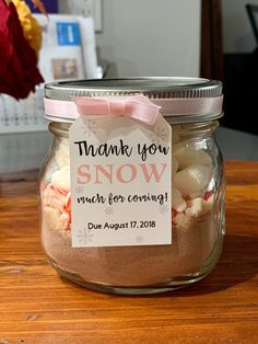 a jar filled with marshmallows on top of a wooden table