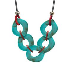 two turquoise and red necklaces hanging from a black cord on a white background,