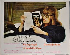 a woman reading a book while laying in bed with glasses on her head and holding a book