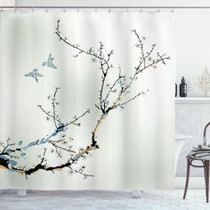 a bathroom with a shower curtain that has birds on the tree branch in front of it