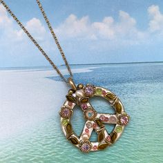 "This lovely peace sign necklace features luminous freshwater pearls crystals artistically set in a unique floral pattern. A handmade, one of a kind necklace that will be treasured by any wearer and includes a gold plated chain. Item Details: -Materials: Swarovski crystals, glass beads, freshwater pearls -Metal: 24K gold electroplated over brass -Size: Chain adjustable 16\"-20\", 1.25\" pendant -Lobster claw clasp -Handmade in our NYC studio -Complimentary gift wrapping -Style number N2316 +Jewe Spiritual Pendant Necklace With Pearl Chain, Vintage Jewelry With Peace Sign As Gift, Vintage Jewelry With Peace Sign For Gift, Spiritual Peace Sign Necklace As A Gift, Peace Sign Jewelry For Gifts, Bohemian Peace Sign Necklace For Gift, Vintage Peace Sign Jewelry Gift, Adjustable Peace Sign Necklace, Peace Sign Jewelry