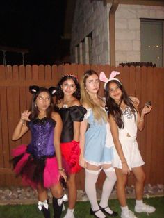 four girls dressed up in costumes posing for the camera with one girl wearing bunny ears