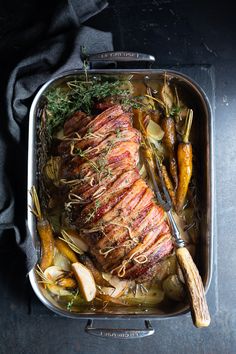 a pan filled with meat and vegetables on top of a table