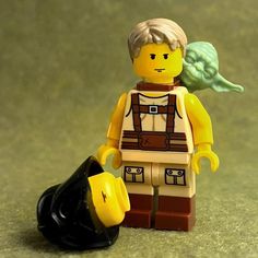 a lego star wars character holding a black trash can with a green leaf on it