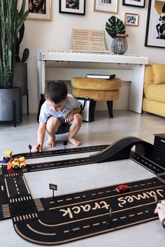 a toddler playing with a toy car set