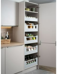 an open pantry door in a kitchen with white cupboards and shelves filled with food