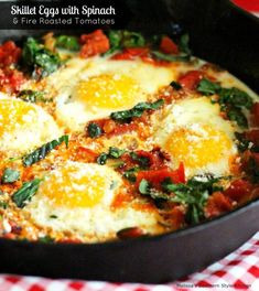 an omelet with eggs and spinach in a skillet on a checkered table cloth