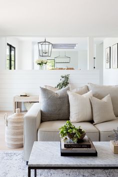 a living room filled with lots of furniture next to a white wall and flooring