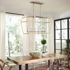 a dining room table with chairs and a bowl of fruit on top of the table