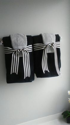 two towels are hanging on the wall next to each other with black and white stripes