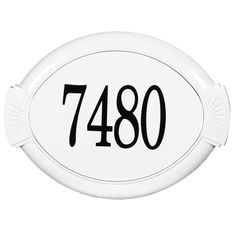 an oval white house number sign with black numbers on the front and bottom, mounted to a wall