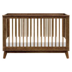 a wooden crib with white sheets on the top and bottom half, in front of a