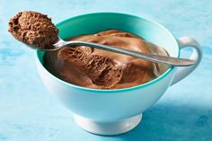 there is a spoon in a bowl with some chocolate ice cream on the top and bottom