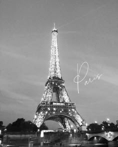 the eiffel tower lit up at night in black and white with writing on it