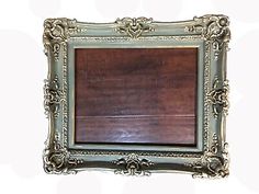 an ornate silver frame with wood in the middle