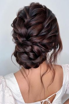 the back of a woman's head with dark brown hair styled into a low bun