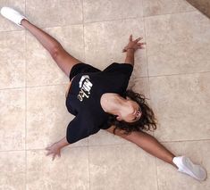 a woman laying on the floor with her arms outstretched