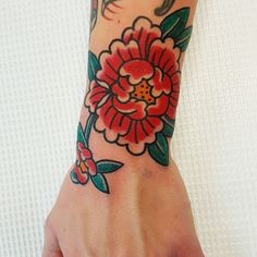 a woman's hand with a flower tattoo on it and a bird sitting on the arm