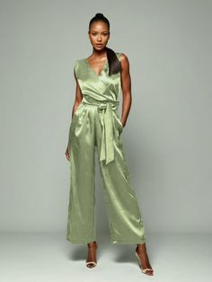 a woman in a green jumpsuit posing for the camera