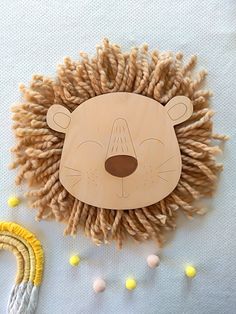 a wooden hedgehog mask sitting on top of a table next to some yarn balls