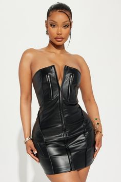 a woman wearing a black leather dress with zippers on the front and side, posing for