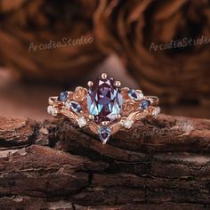 a ring with blue and white stones on it sitting on top of a tree stump