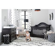 a baby is sitting in a black and white nursery