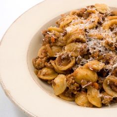 a white bowl filled with pasta and meat