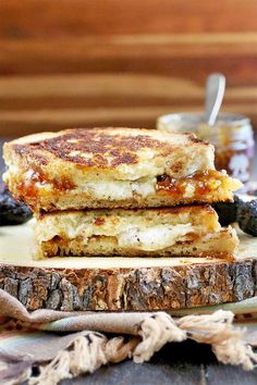 two grilled cheese sandwiches stacked on top of each other next to some black olives