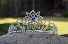 Let your inner snow queen shine with this amazing tiara! 3 options for the center stone of the snowflake: clear rhinestone, sapphire blue rhinestone, or glow in the dark glass bead (to charge, simply leave in the sunlight for a few minutes. Beautiful by day, glowing by night!). This tiara features glass rhinestones and a metal band. One size fits all, fits children and adults alike. Is this a gift? No worries...it will include instructions professionally printed on a postcard. The recipient will Winter Crown, Rapunzel Cosplay, Queens Tiaras, Elsa Costume, Beautiful Tiaras, Princess Necklace, Rhinestone Tiara, Ice Princess, Mermaid Necklace